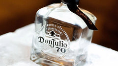Don Julio 70 tequila bottle on a white surface with a blurred background