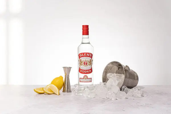 Glen's Vodka bottle with ice, lemons, and a cocktail shaker on a white background