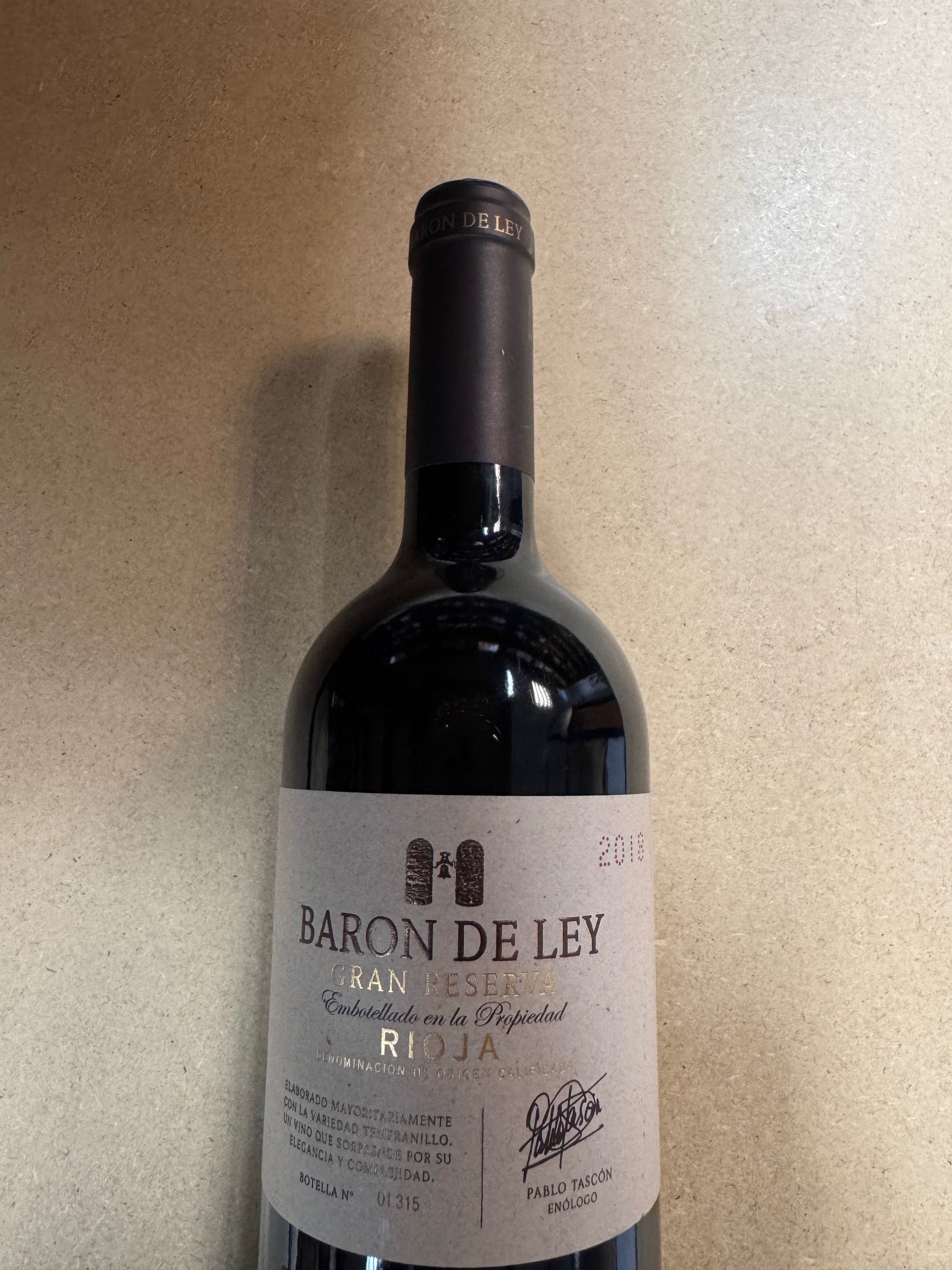 Wine bottle with 'Baron de Ley' label on a beige surface