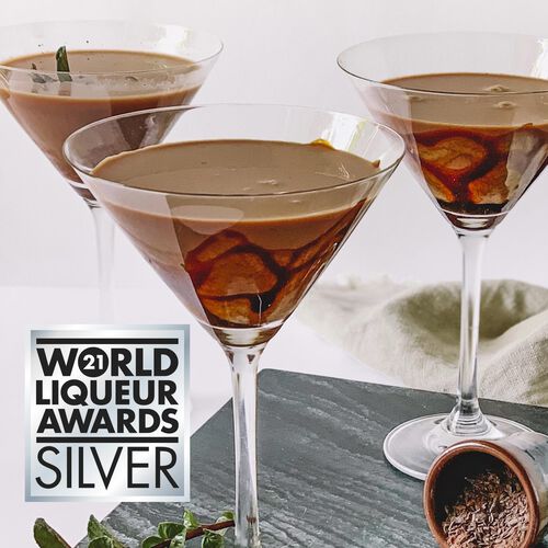 Three martini glasses with a chocolate liqueur cocktail on a gray surface, with 'World Liqueur Awards Silver' logo.