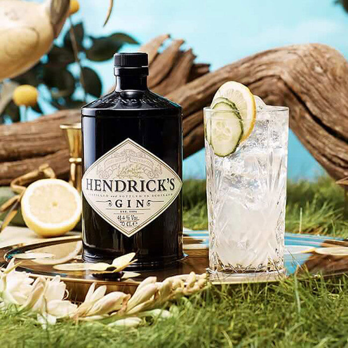 Hendrick's Gin bottle with a glass of gin and tonic on a natural background