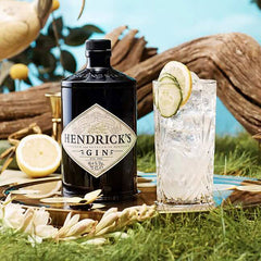 Hendrick's Gin bottle with a glass of gin and tonic on a natural background