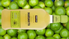 Kerrland Margarita bottle on a background of green limes