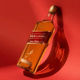 Johnnie Walker Red Label whisky bottle on a red background