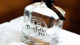 Don Julio 70 tequila bottle on a white surface with a blurred background