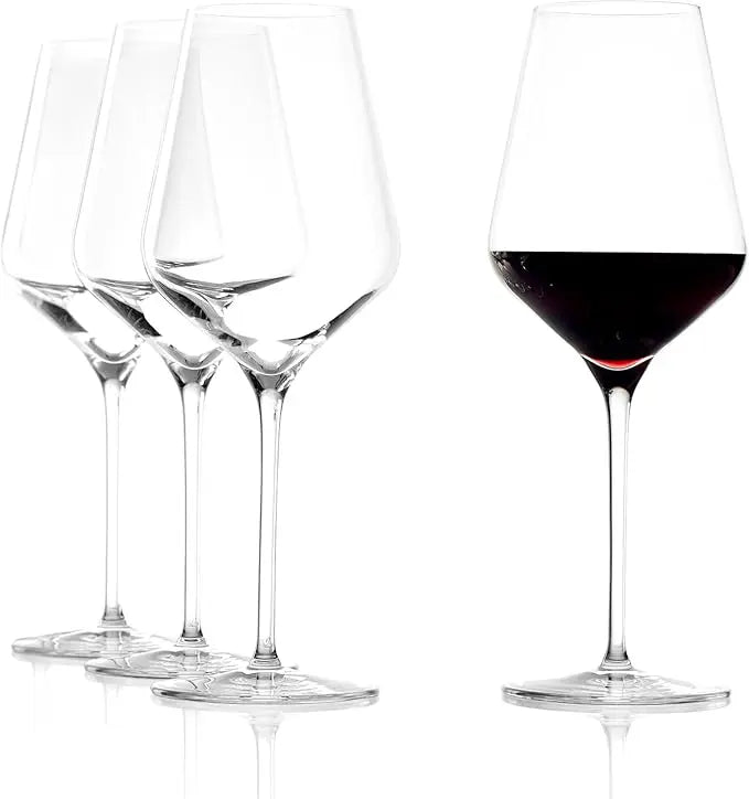 Set of wine glasses with one filled with red wine on a white background