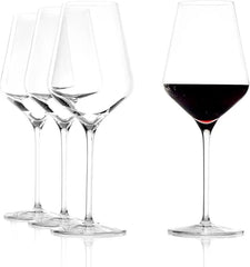 Set of wine glasses with one filled with red wine on a white background