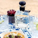 Don Julio 70 tequila bottle on a table with food and glasses