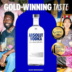Absolut Vodka bottle with gold-winning text and people in the background