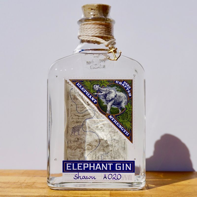 Bottle of Elephant Gin with a label featuring an elephant design on a wooden surface.