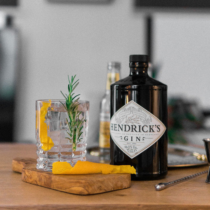 Hendrick's Gin bottle with a cocktail on a wooden board