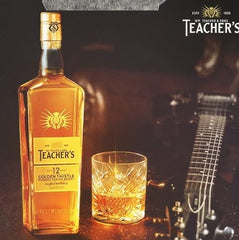 Teacher's 12 Year Review whiskey bottle with a glass and guitar in the background