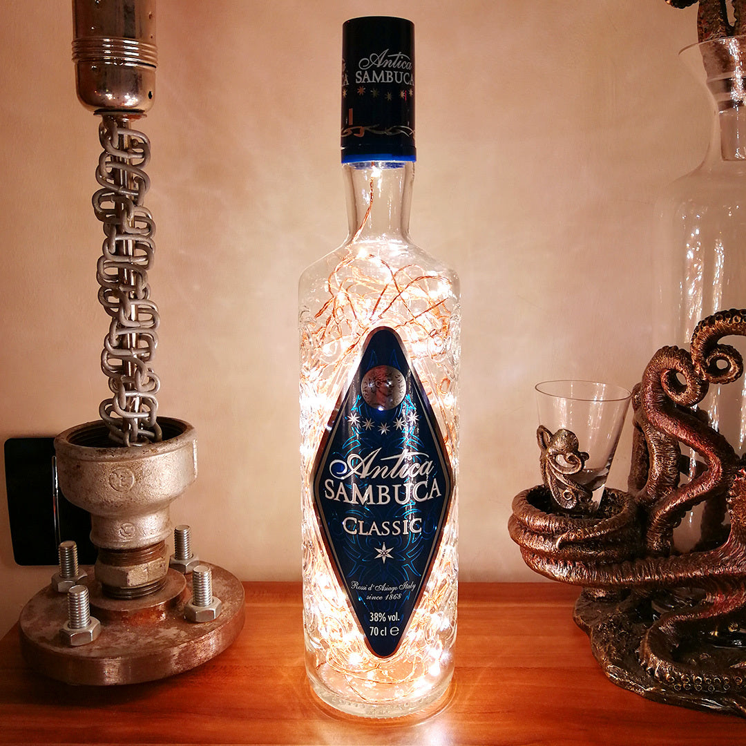 Antica Sambuca Classic bottle with LED lights on a wooden surface