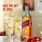 Johnnie Walker Red Label whisky bottle with cocktails and a ribbon on a blurred background