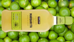 Kerrland Margarita bottle on a background of green limes